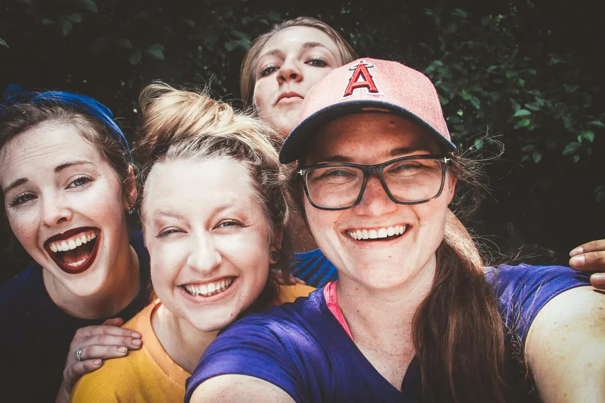 Drei Frauen lachen gemeinsam in die Kamera