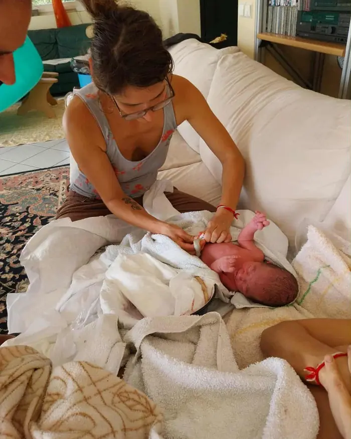 Ursina untersucht bei einem Hausbesuch ein Neugeborenes