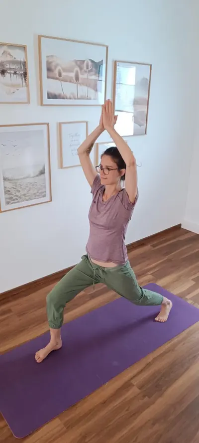 Ursina in einer Yoga-Haltung mit erhobenen Armen